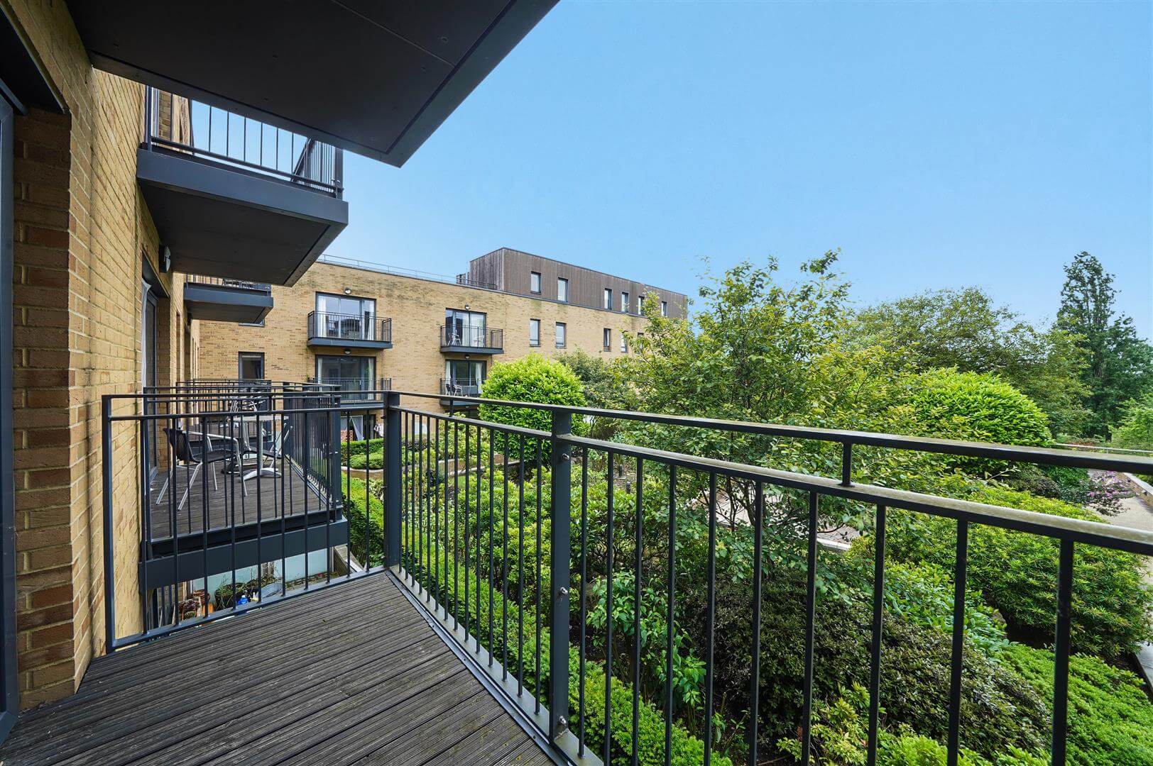 Balcony view with blue sky and trees and shrubs
