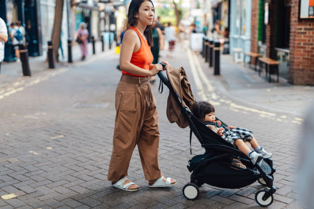 Woman pushing pram in a busy city street