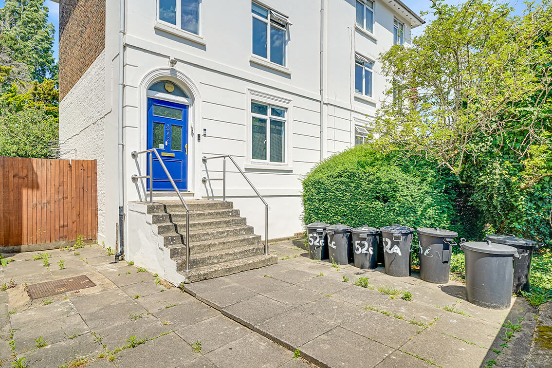 External view of a three storey terraced property on Allfarthing Road with steps leading to a blue front door.