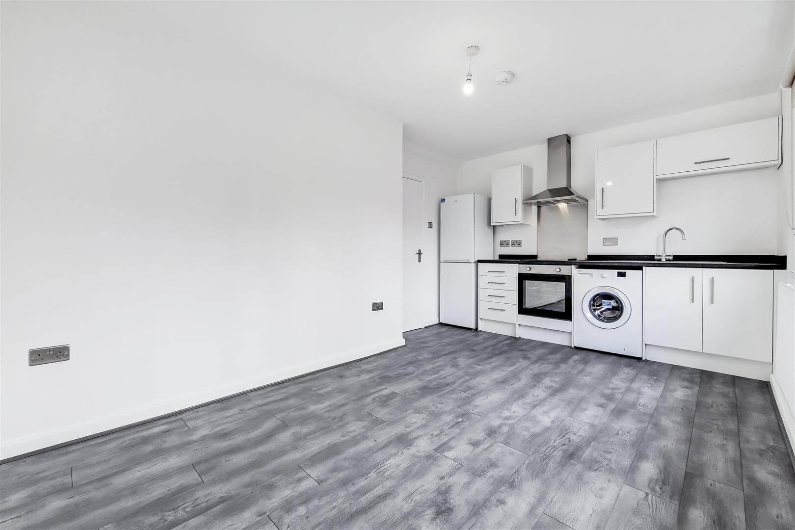 Refurbished Kitchen with white walls, grey flooring, white kitchen units, freestanding fridge/freezer, washing machine, oven and extractor hood